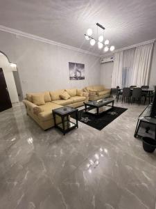 a living room with a couch and tables and chairs at Fully furnished family house in Al Madinah
