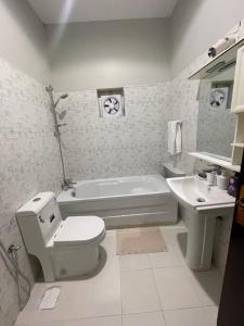a white bathroom with a toilet and a sink at Fully furnished family house in Medina