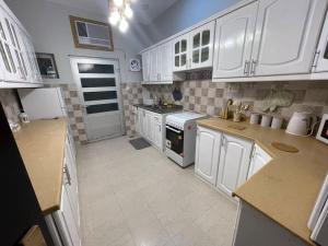 a kitchen with white cabinets and white appliances at Fully furnished family house in Al Madinah
