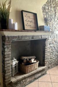 a stone fireplace with a picture and a basket at Residenza Borgo 9 in Collecchio