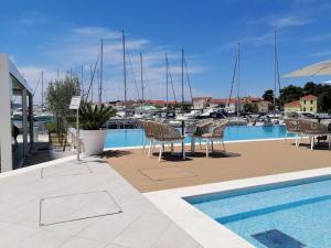 un patio con tavolo e sedie accanto a un porto turistico di Karmen Luxury Apartments Borik a Zara (Zadar)