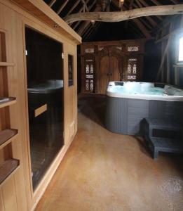 um quarto grande com uma banheira numa casa em Gite de la Chapelle option SPA em Verchocq