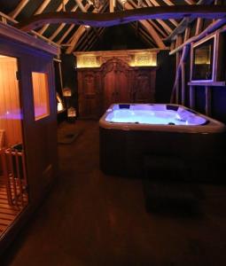 uma grande casa de banho com banheira num quarto em Gite de la Chapelle option SPA em Verchocq