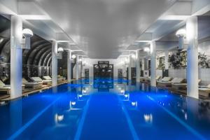 a swimming pool with blue water in a building at Amathus Beach Hotel Limassol in Limassol