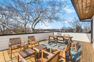 un patio con mesas de madera y sillas en el techo en Modern Luxury Rooftop Deck, 3 mi to Downtown, en Nashville