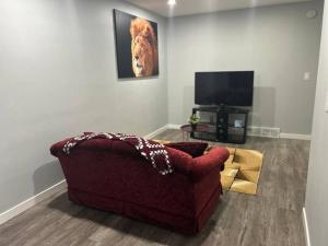 a living room with a red couch and a television at Cute Highland Park Entire Unit B in Calgary