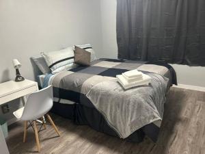 Schlafzimmer mit einem Bett, einem Schreibtisch und einem Stuhl in der Unterkunft Cute Highland Park Entire Unit B in Calgary