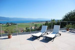 - deux chaises sur une terrasse avec vue sur l'eau dans l'établissement Romantic Châlet with TOP Panorama, à Châtillon