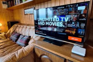 a large flat screen tv sitting on top of a couch at Romantic Châlet with TOP Panorama in Châtillon