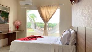 a bedroom with a bed and a large window at HOTEL DA MARGEM in Manaus