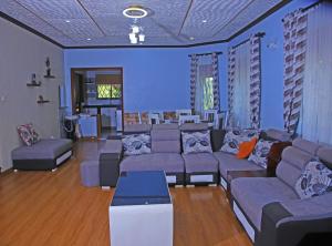 a living room with blue walls and couches at Heavenly Royalz Farm Fortportal in Njara