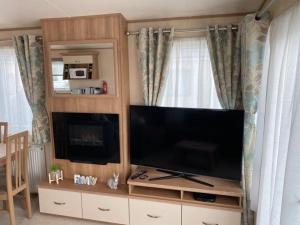 un ampio centro di intrattenimento con una grande TV a schermo piatto di KINGFISHER COURT 2 Tattershall lakes with hot tub a Tattershall