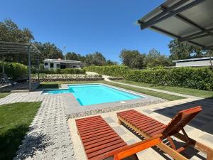 a swimming pool with a pair of lawn chairs and a swimming pool at Amazilia Guesthouse in Liberia