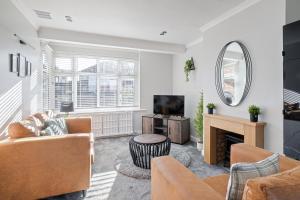 a living room with a couch and a tv at Stylishly Decorated 3-bed House in Bedford