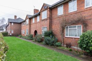 a red brick house with a green yard at Stylish & Spacious 3bed in Putney in London