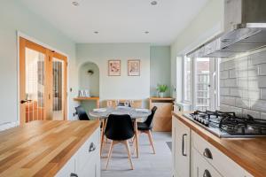 a kitchen with a table and a stove at Stylishly Decorated 3-bed House in Bedford