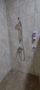 a shower with a shower head in a bathroom at V3 appartement in Paramaribo