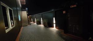 a hallway with potted plants on a building at night at V3 appartement in Paramaribo