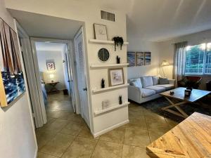 een woonkamer met een bank en een tafel bij Renovated Cozy Apartment in Naples (1.4 miles from the beach) in Naples