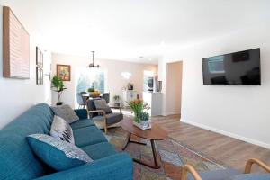 a living room with a blue couch and a table at Beautiful 3 Bed 1 Bath Designer Home + Hot Tub in North Hollywood