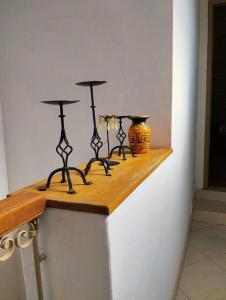 ein Regal mit drei schwarzen Kerzenständern an der Wand in der Unterkunft Mangoty Apartamento in Luque