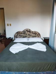 um quarto com uma cama com lençóis brancos e uma cabeceira em Mangoty Apartamento em Luque