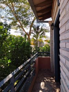 eine Veranda eines Hauses mit einem Zaun und Bäumen in der Unterkunft Mangoty Apartamento in Luque