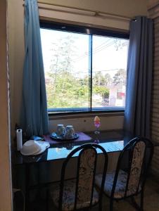 Luque的住宿－Mangoty Apartamento，餐桌、两把椅子和窗户