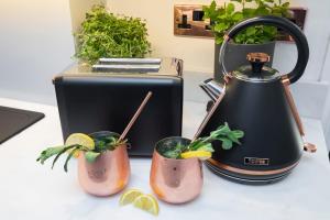 a tea kettle and two cocktails in holders on a counter at Pittville Circus Road in Cheltenham