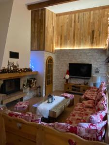 sala de estar con muebles y TV de pantalla plana. en LE VERTBRUCHE - Gîte avec superbe vue pour 15 pers, en La Bresse