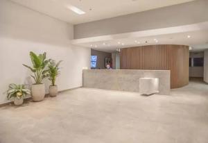 a lobby with potted plants and a counter in a building at Hermoso Apartamento tipo Loft en Rodadero Santa Marta in Santa Marta +64 photos