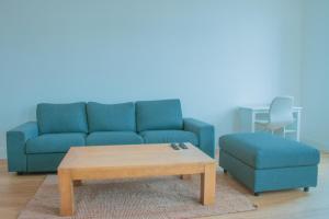 a living room with a blue couch and a coffee table at Grand 2P vue seine in Mantes-la-Jolie