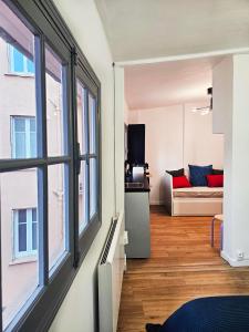 a living room with a large window and a couch at L'Idrac, Appartements en Hyper centre in Toulouse