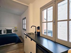 Schlafzimmer mit einem Bett und einem Schreibtisch mit einem Fenster in der Unterkunft L'Idrac, Appartements en Hyper centre in Toulouse
