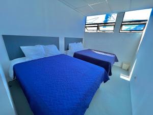 1 dormitorio con 2 camas y 2 ventanas en Hotel Citadin zona 5, en Guatemala