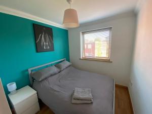 a bedroom with a bed and a blue wall at Apt 7 Cathedral & River view in Norwich