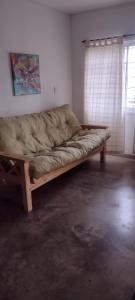 - un canapé en bois dans une chambre avec fenêtre dans l'établissement La chacrita en San Miguel del Monte, à San Miguel del Monte