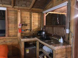 a kitchen in a log cabin with a sink at Cabaña en Villa de Leyva Se Permiten Mascotas Pet Friendly in Villa de Leyva
