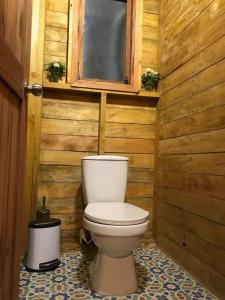 a toilet in a wooden bathroom with a window at Cabaña en Villa de Leyva Se Permiten Mascotas Pet Friendly in Villa de Leyva