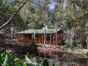 a cabin in the woods with a pond in front of it at Cabaña en Villa de Leyva Se Permiten Mascotas Pet Friendly in Villa de Leyva +12 photos