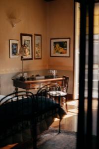 um quarto com uma secretária com um candeeiro e cadeiras em B&B Palazzo Melluso em Porto Empedocle