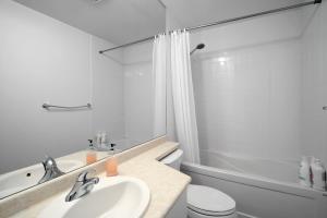 a white bathroom with a sink and a toilet at DownTown Toronto luxury condo in Toronto