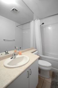 a white bathroom with a sink and a toilet at DownTown Toronto luxury condo in Toronto