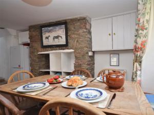 una cucina con tavolo in legno e cibo di 3 Bed in Salcombe 75138 a Bigbury