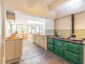 a large kitchen with green cabinets and a table at 9 Bed in Keswick SZ238 in Keswick
