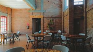 een groep tafels en stoelen in een kamer met bakstenen muren bij La Piedra del Tesoro Campamento in El Zepo