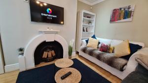 a living room with a couch and a fire place at Stylish 2 Bedroom Apartment, Leeds Centre + Free Parking in Leeds