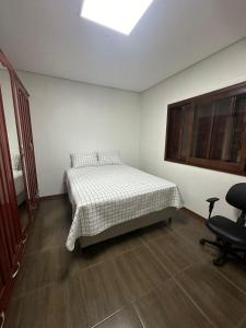 1 dormitorio con 1 cama y 1 silla en Casa Liberdade, en Novo Hamburgo