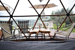 a table and chairs on a deck with a view at URQU Glamping cerca a Bogota in Silvania