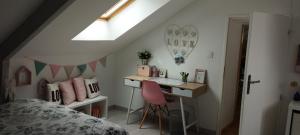 ein Schlafzimmer mit einem Schreibtisch und einem Bett und einem Fenster in der Unterkunft Chambres dans maison campagne circuit LE MANS in Roézé-sur-Sarthe